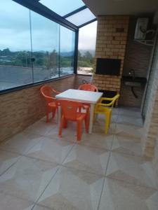 a table and chairs on a balcony with a view at Apartamento completo 1 quarto in Palhoça