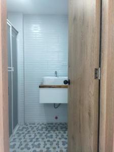 ein Badezimmer mit einem weißen Waschbecken und einer Dusche in der Unterkunft ROZA apartaments & suits in Loja