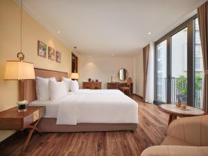 ein Schlafzimmer mit einem großen weißen Bett und einem großen Fenster in der Unterkunft Nesta Hotel & Spa in Hanoi