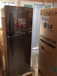 a refrigerator and a box in a room at un nouveau appartement avec un parking gratuit sur place in La Marsa