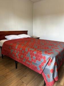 Un dormitorio con una cama con una manta de colores. en Travel Inn Montgomery AL en Montgomery
