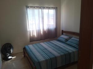 Schlafzimmer mit einem Bett, einem Fenster und einem Ventilator in der Unterkunft Bem estar in Aparecida