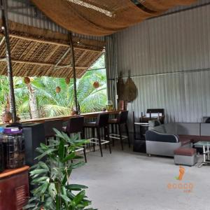 Ecoco Homestay Mekong في Ben Tre: مطعم فيه كراسي وطاولات ونافذة كبيرة