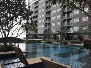 a swimming pool with chairs and a building at The Trust @BTS Chang Erawan. in Ban Bang Yai