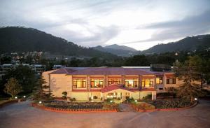 a large building with a lot of windows at Country Inn Nature Resort Bhimtal in Bhīm Tāl