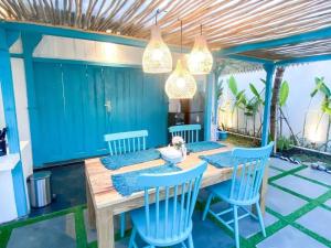 ein Esszimmer mit einem Holztisch und blauen Stühlen in der Unterkunft Ubu Villa Prambanan - 3 Bedrooms Villa near Prambanan Temple in Prambanan