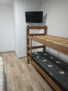 een kamer met een stapelbed en een flatscreen-tv bij Apartamento completo praia do sonho in Palhoça