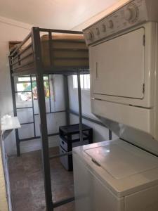 a kitchen with a bunk bed and a refrigerator at Skyline Siesta: Chic Couch Quarters in Heart of Echo Park – DTLA Awaits in Los Angeles