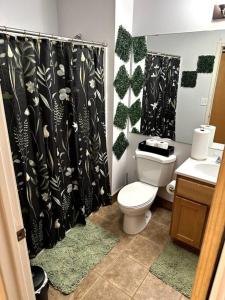 a bathroom with a toilet and a black shower curtain at Serene Living Downtown STL Loft in Saint Louis