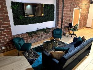 a living room with a couch and a tv on a brick wall at Serene Living Downtown STL Loft in Saint Louis