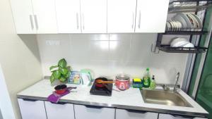 a kitchen counter with a sink and dishes on it at 3A YOLO Budget Condo in Kuala Lumpur