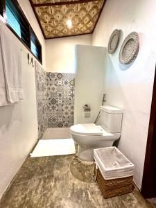 a bathroom with a white toilet in a room at Yumi Villas in San Vicente