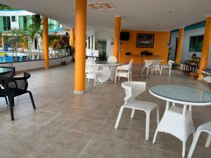 a lobby with tables and chairs and a pool at Hotel la cascada cristalina in Melgar