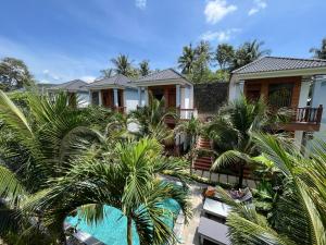 a house with palm trees and a swimming pool at Valentina Resort & Spa Phu Quoc in Phú Quốc