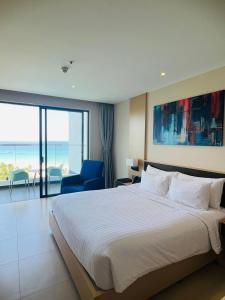 een slaapkamer met een groot bed en een blauwe stoel bij Cam Ranh Sea View apeartment Nha Trang in Cam Ranh