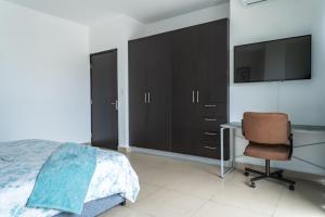 a bedroom with a bed and a desk and a television at Apartamento en San Francisco in Panama City