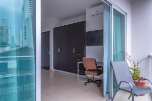 um escritório com uma secretária e cadeiras e uma janela em Apartamento en San Francisco em Cidade do Panamá