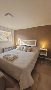 a bedroom with a large bed with two towels on it at Ekos de Saint Exupery in El Chalten