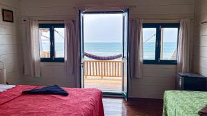 a bedroom with two beds and a view of the ocean at The Nest Palolem in Canacona