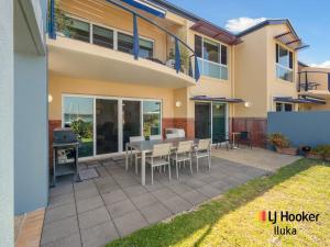 a patio with a table and chairs in front of a house at Riverview Apartments 1 3 Building 1 Unit 3 in Iluka