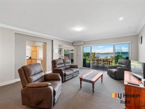 ein Wohnzimmer mit Sesseln und einem TV in der Unterkunft Riverview Apartments 1 3 Building 1 Unit 3 in Iluka