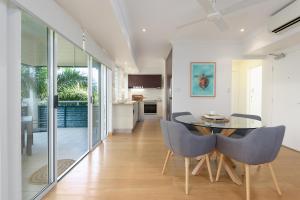 a dining room with a table and chairs at Verandahs Boutique Apartments in Port Douglas