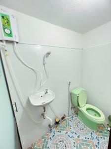 Homestay YẾN HÒA في Ấp Bình Hưng: حمام به مرحاض أخضر ومغسلة