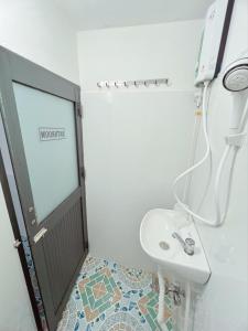 bagno bianco con lavandino e doccia di Homestay YẾN HÒA a Ấp Bình Hưng