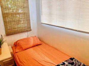 Cama naranja en habitación con ventana en Urban Oasis with Private Laundry: Steps from DTLA, en Los Ángeles 6 fotos más