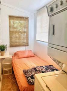 a small bedroom with a bed and a window at Urban Oasis with Private Laundry: Steps from DTLA in Los Angeles