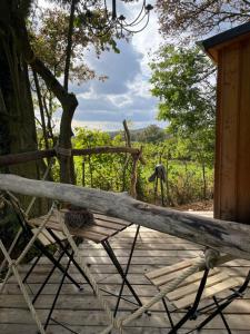 a wooden bench sitting on a wooden deck at Eulennest - Tiny House im Habichtswald in Schauenburg
