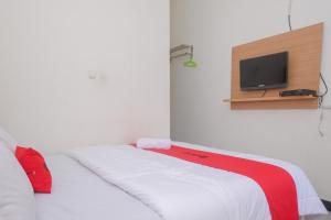 a bedroom with a bed with a tv on the wall at RedDoorz Syariah @ Jalan Dieng Wonosobo 2 in Garung