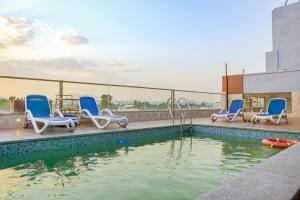 a swimming pool with blue chairs and a swimming pool at Pax Grand Blue in Udaipur