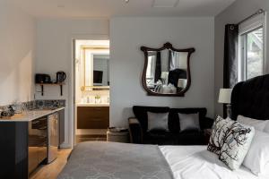 a bedroom with a bed and a sink and a mirror at Ascona - Hepburn Springs Daylesford in Hepburn Springs +50 photos