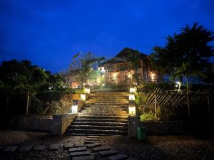 um conjunto de escadas que levam a uma casa à noite em La Montana De Luong Son 