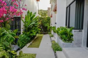a garden with plants and flowers next to a building at Leafy Lofts Canggu in Canggu