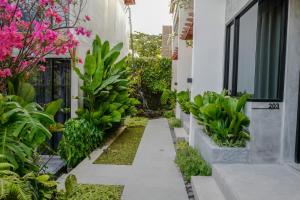 een tuin met planten en bloemen naast een gebouw bij Leafy Lofts Canggu in Canggu