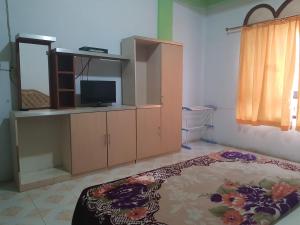 een woonkamer met een tv en een kast bij OYO 93237 Hotel Triarga in Takengon