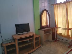 a living room with a tv and a table with a tvictericter at OYO 93237 Hotel Triarga in Takengon