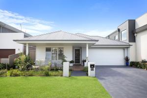 a white house with a white garage at Waiheke Marina Getaway in Shellharbour