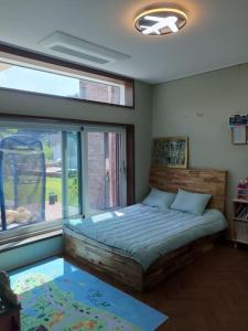 a bedroom with a bed and a large window at Feel House in Goyang
