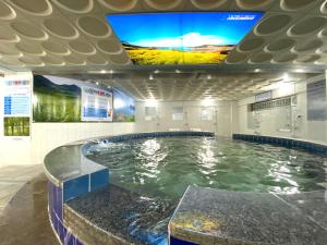 a large swimming pool with a tv on the ceiling at Suanbo Hot Spring Healing Hotel in Chungju