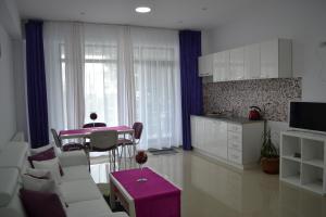 a kitchen and living room with a table and chairs at City Park Residence in Constanţa