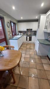 a kitchen with white cabinets and a table and a table and a tableearcher at The Nest Antrim in Antrim