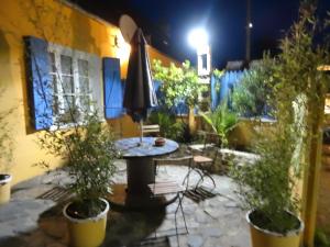 a patio at night with a table and plants at Gîtes Rose des Sables in Surtainville