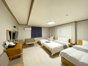 una camera d'albergo con due letti e una televisione di Suanbo Hot Spring Healing Hotel a Chungju
