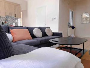 a living room with a blue couch and a table at Faliro Athens fully equipped sea view apartment 200m to beach in Athens