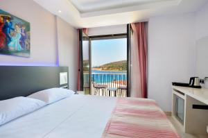 a bedroom with a bed and a view of the ocean at Datca Sapphire Hotel in Datca
