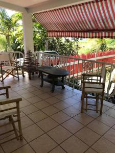 un patio con mesa, sillas y una valla en Toda la casa: 3 dormitorios, 4 baños y 1 futón., en Arecibo