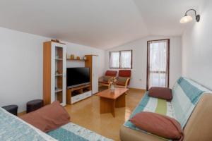 ein Wohnzimmer mit einem Sofa und einem TV in der Unterkunft Apartment Lili-with paddling pool in Umag